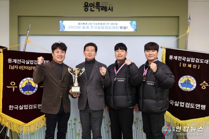 이상일 용인특례시장이 14일 동계 전국실업검도대회에서 우승한 시 검도팀에게 우승기를 전달받고 기념촬영을 하고 있다