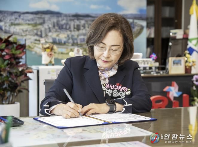 박희영 용산구청장이 지역경제 활성화를 위한 특별신용보증지원 업무협약서에 서명하고 있다