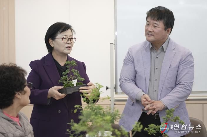 이순희 강북구청장(왼쪽 첫 번째)이 화계중학교를 방문해 최중호 교장과 함께 평생학습 프로그램 ‘국화분재 수업’에 참여한 주민들과 대화를 나누고 있다.