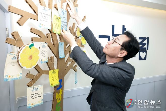 정명근 화성특례시장이 그냥드림 내부 '희망나무'에 작성한 쪽지를 달고 있다.